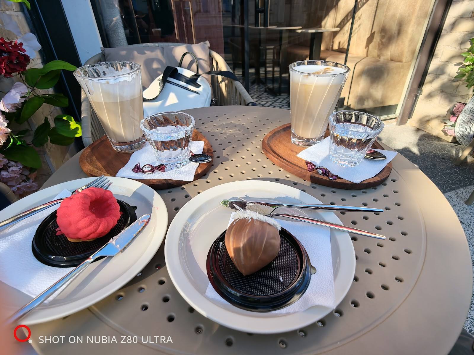 Plated desserts and beverages on a sunny outdoor terrace