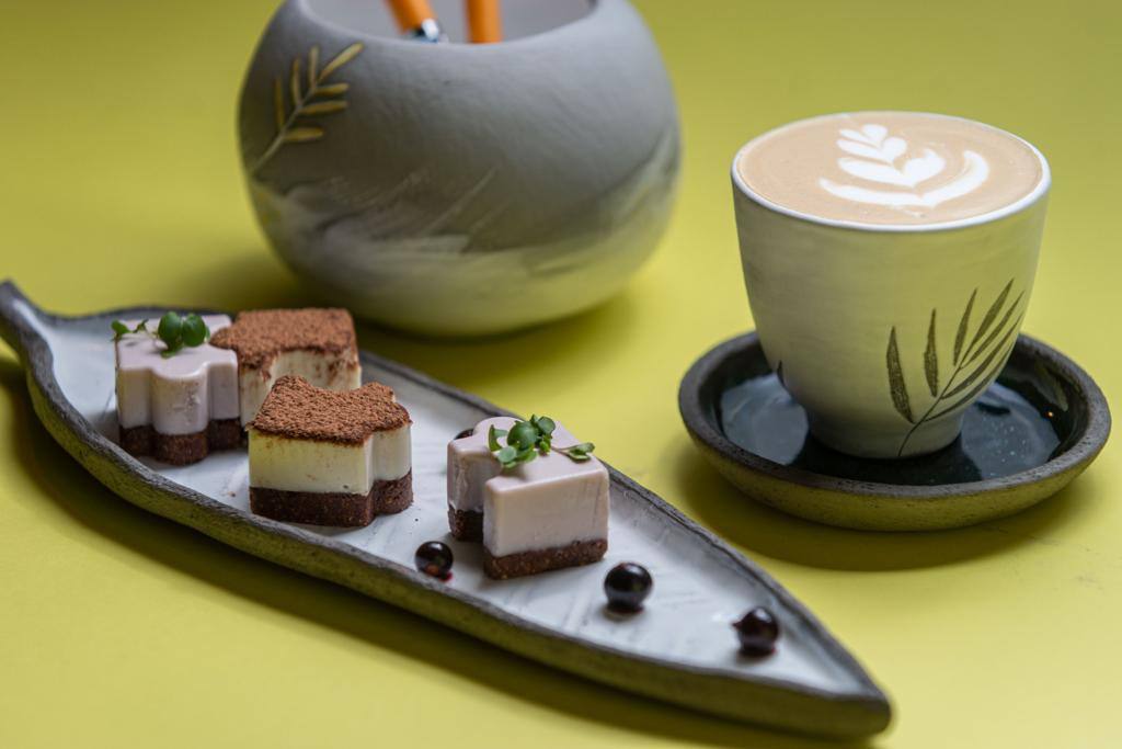 Plated desserts and latte on yellow background