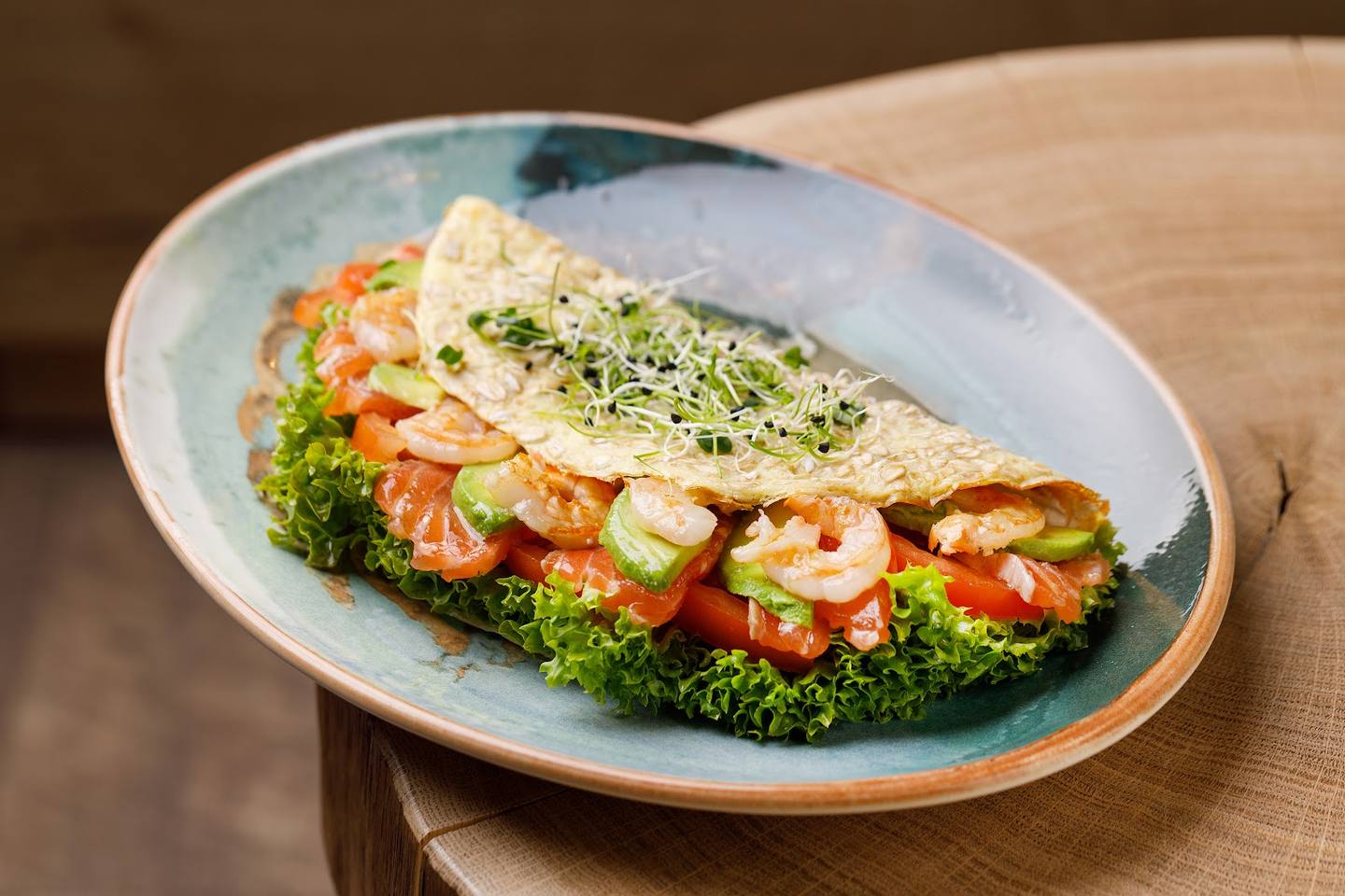 Pan-seared fish fillet with shrimp and microgreens on ceramic plate