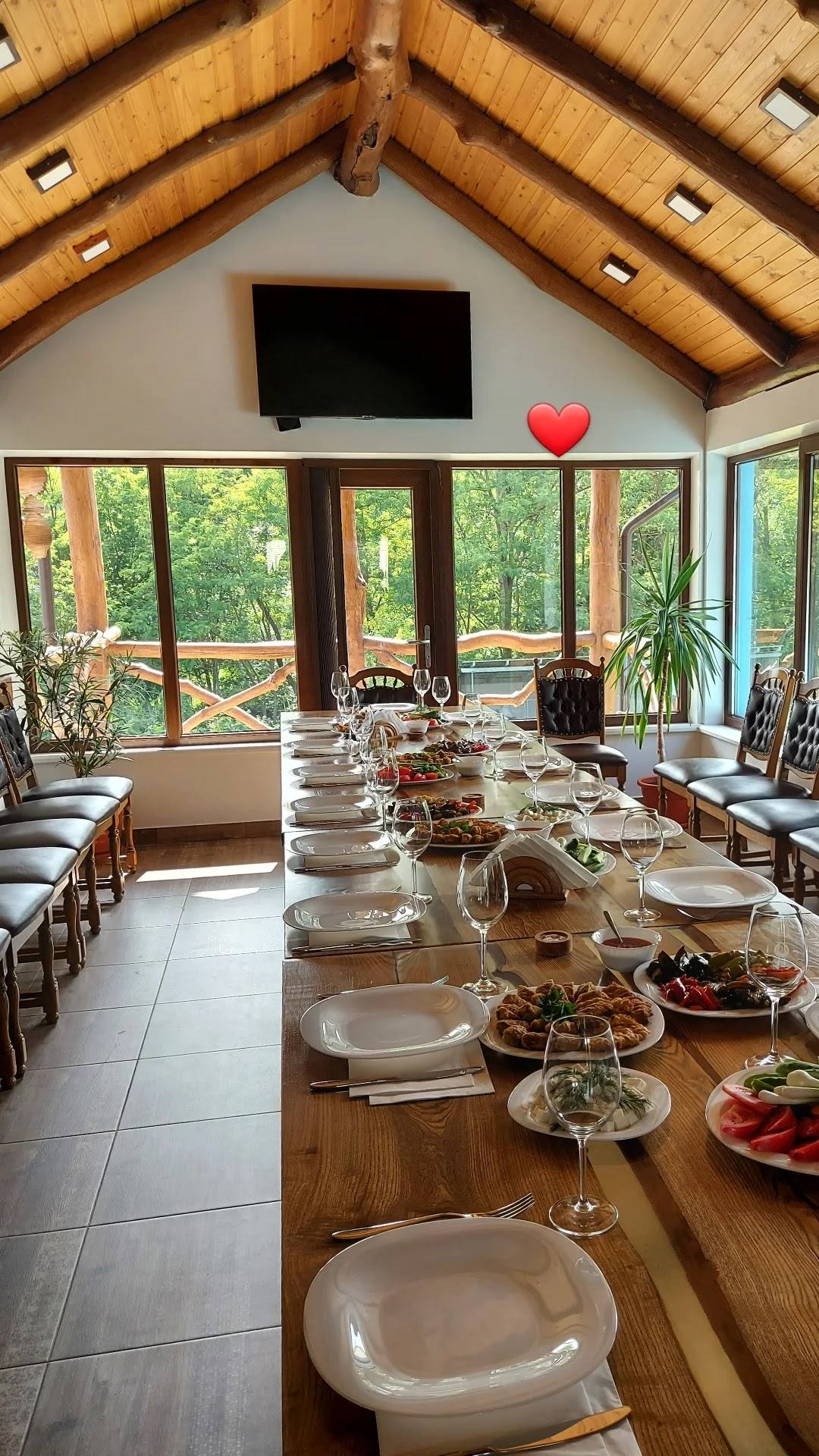 Elegant dining room with vaulted wooden ceiling and large windows overlooking gardens