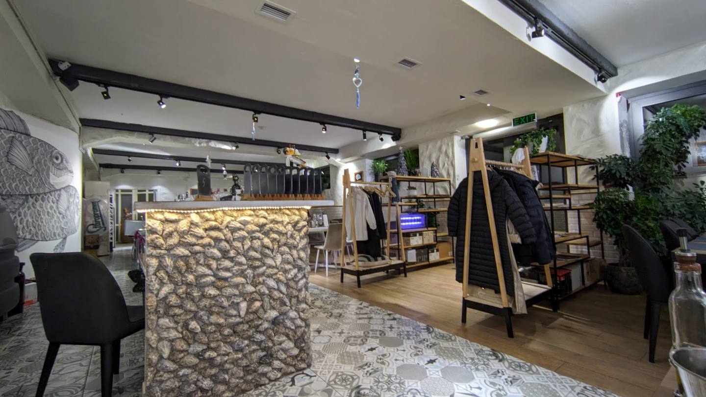 Modern retail boutique with textured accent wall, clothing displays, and welcoming interior lighting
