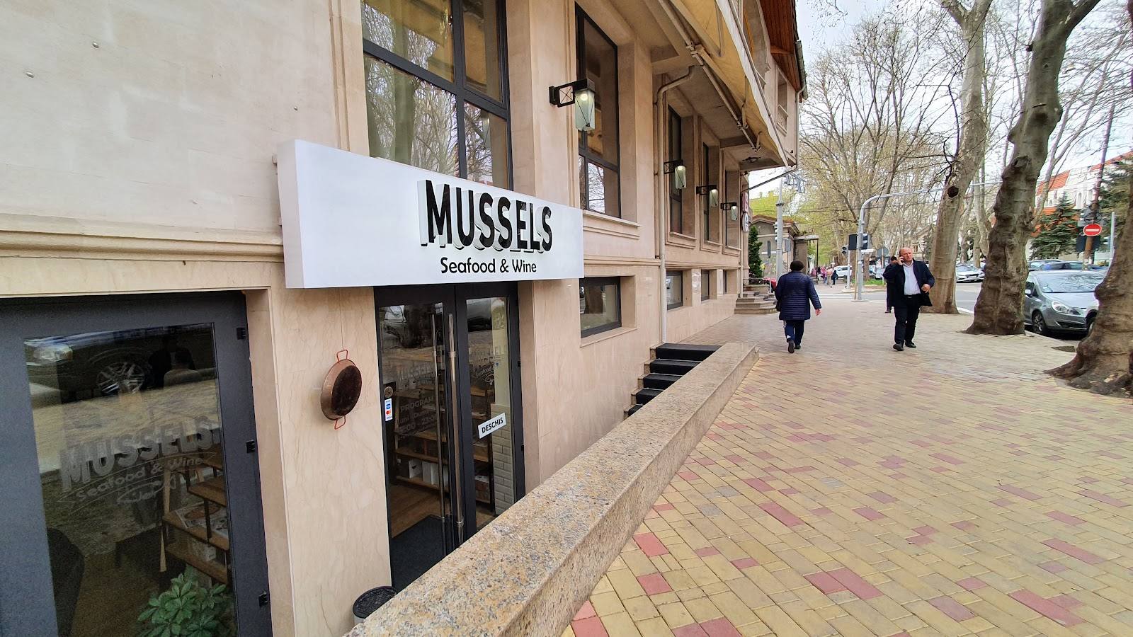 MUSSELS storefront on pedestrian street with outdoor terrace view