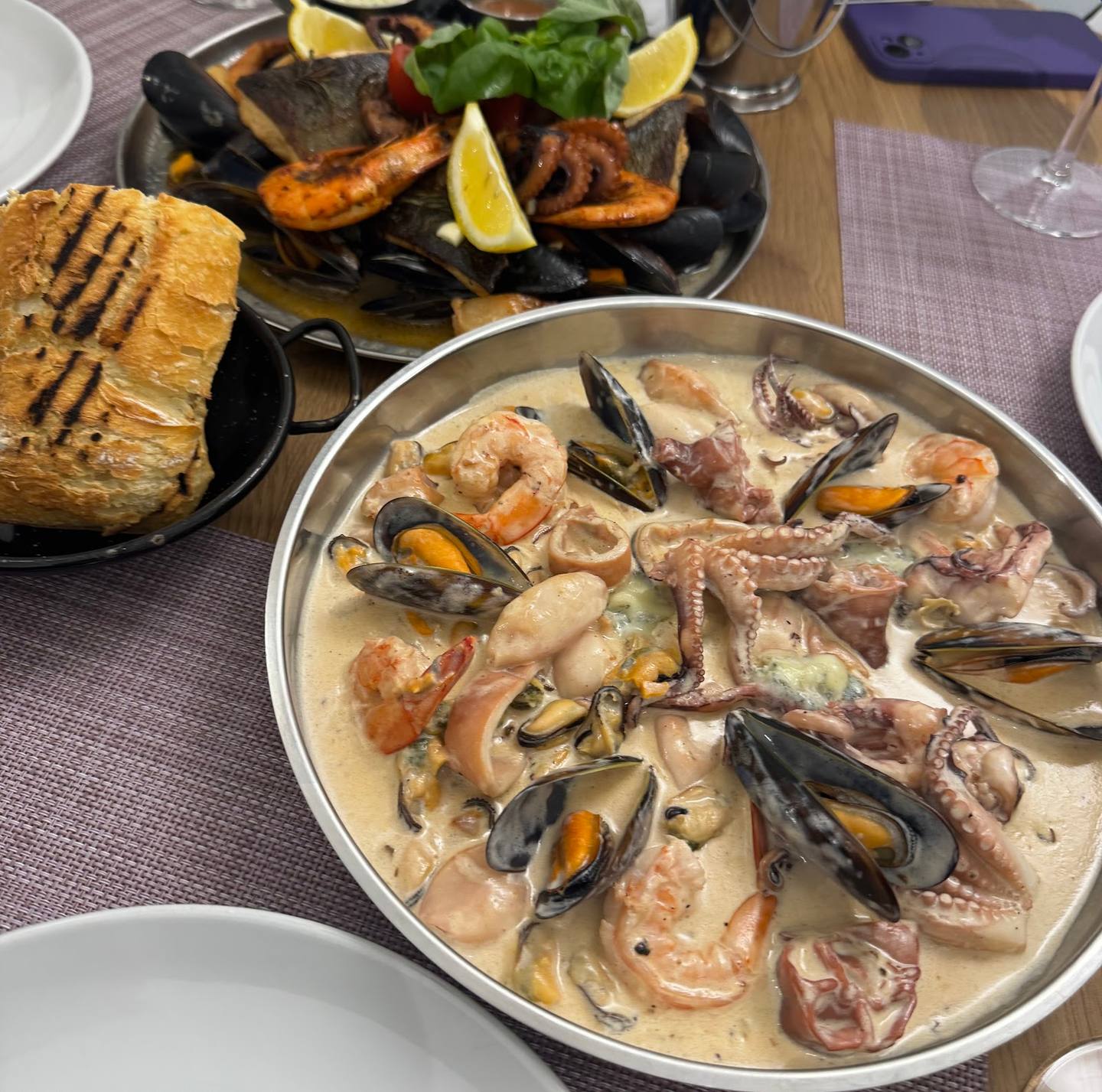 Seafood platters with mussels and prawns in creamy sauce, grilled bread