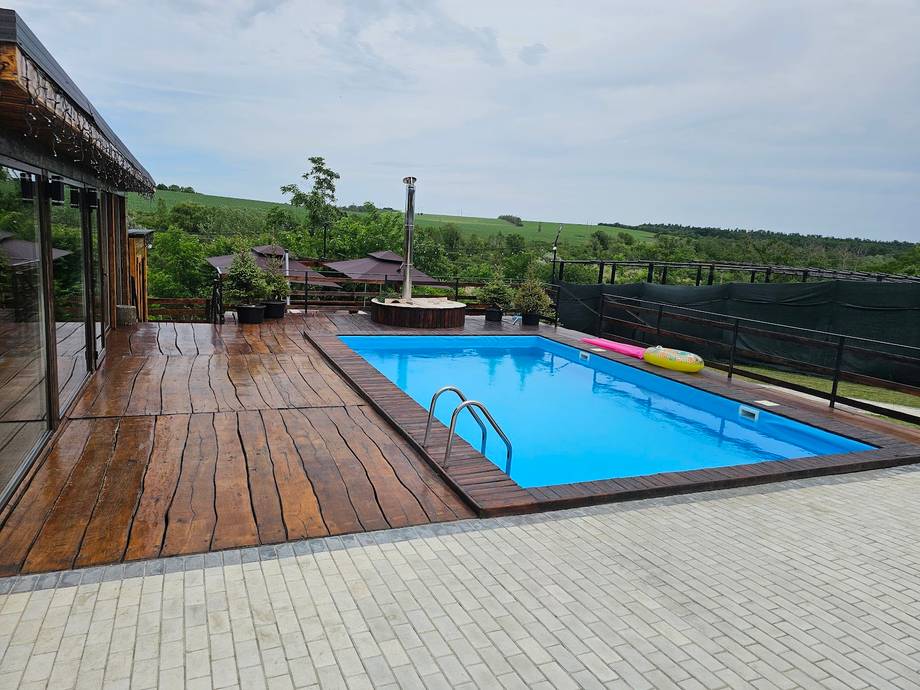 Outdoor swimming pool with wooden deck and vineyard views in Moldova