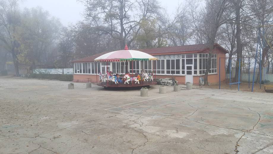 Red and white pavilion venue with expansive courtyard in park setting