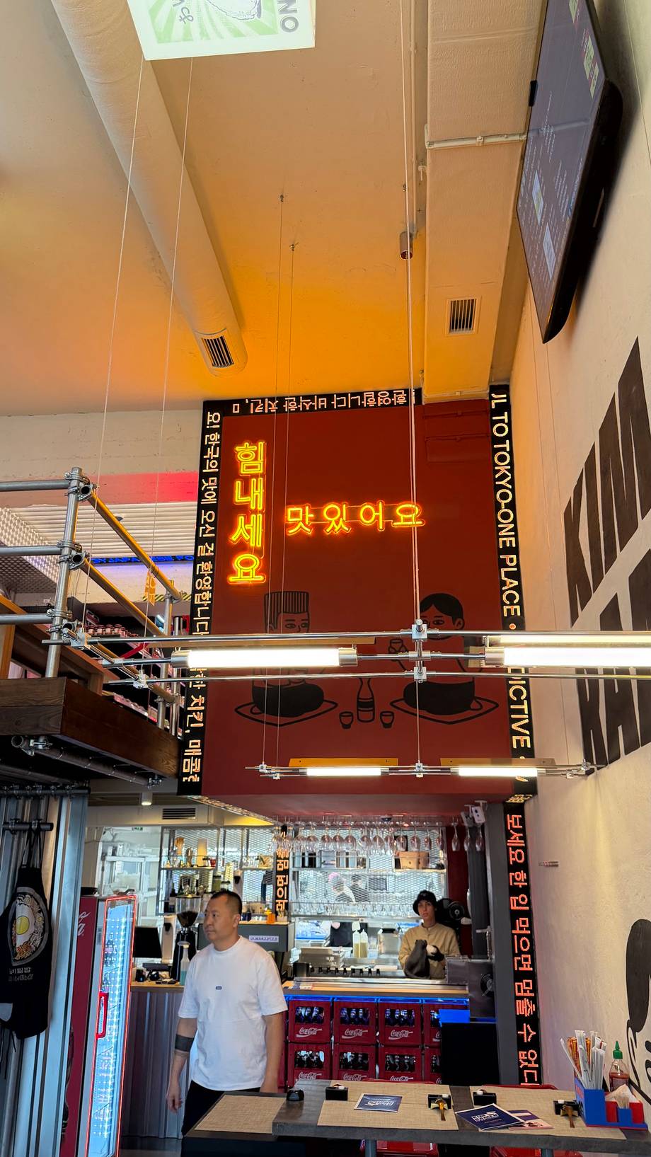 Interior view of Korean cafe or restaurant with counter service and neon signage