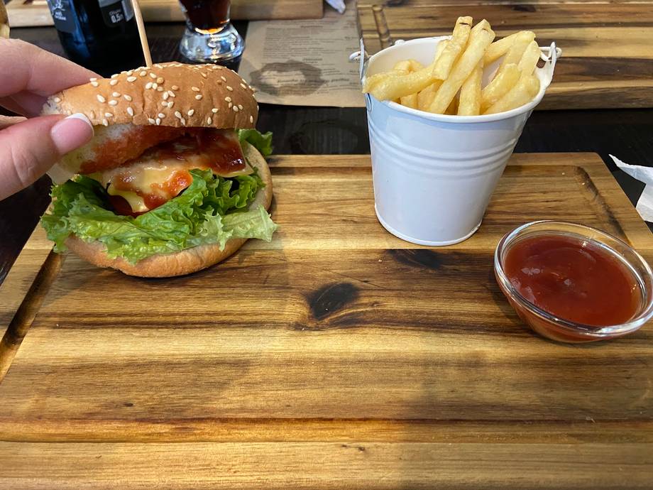 Burger, fries and ketchup served on wooden table