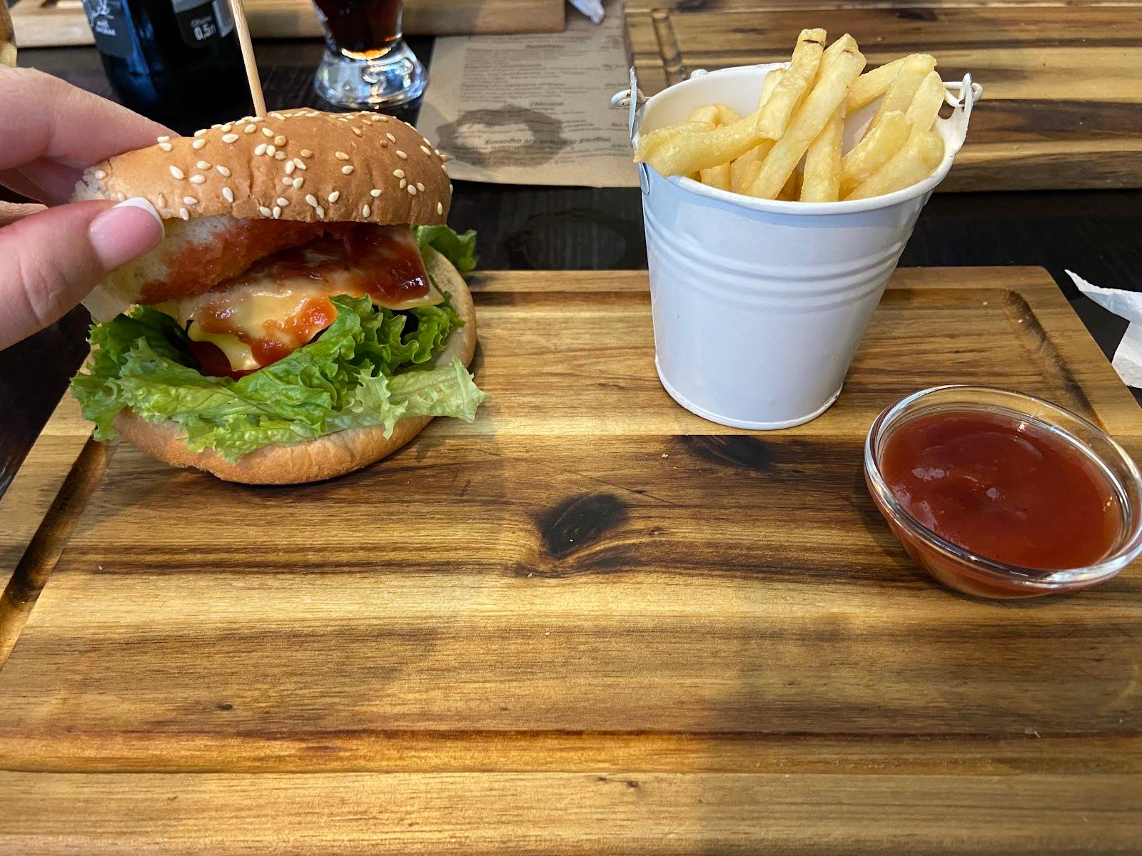 Burger, fries and ketchup served on wooden table