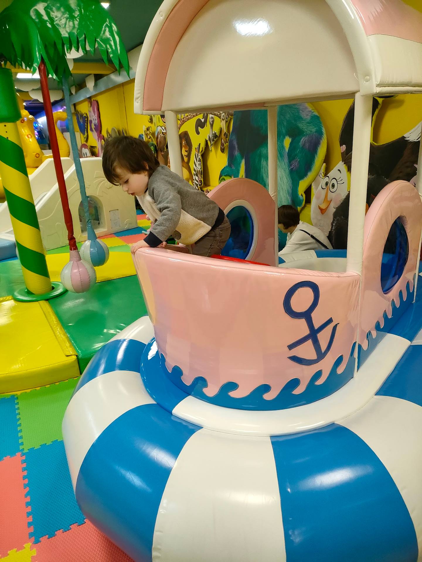 Child playing in nautical-themed ride at indoor play center