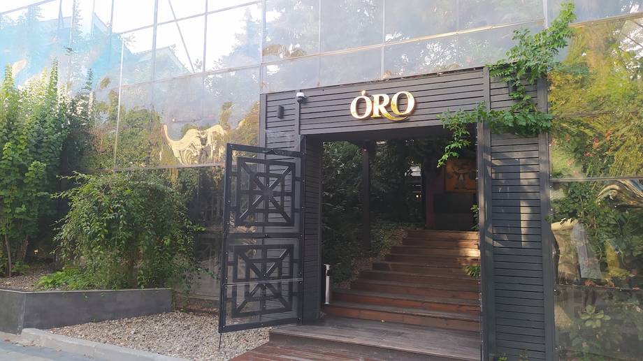 ORO venue storefront with black entrance gate and modern wooden deck