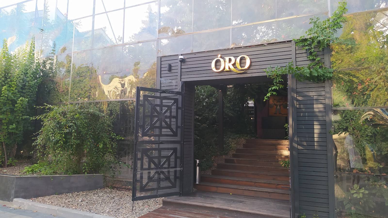 ORO venue storefront with black entrance gate and modern wooden deck