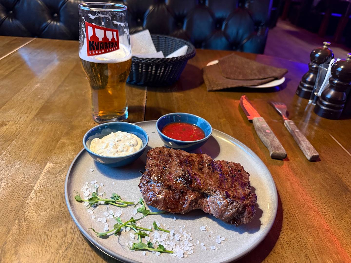 Grilled meat steak with sides and craft beer at restaurant bar