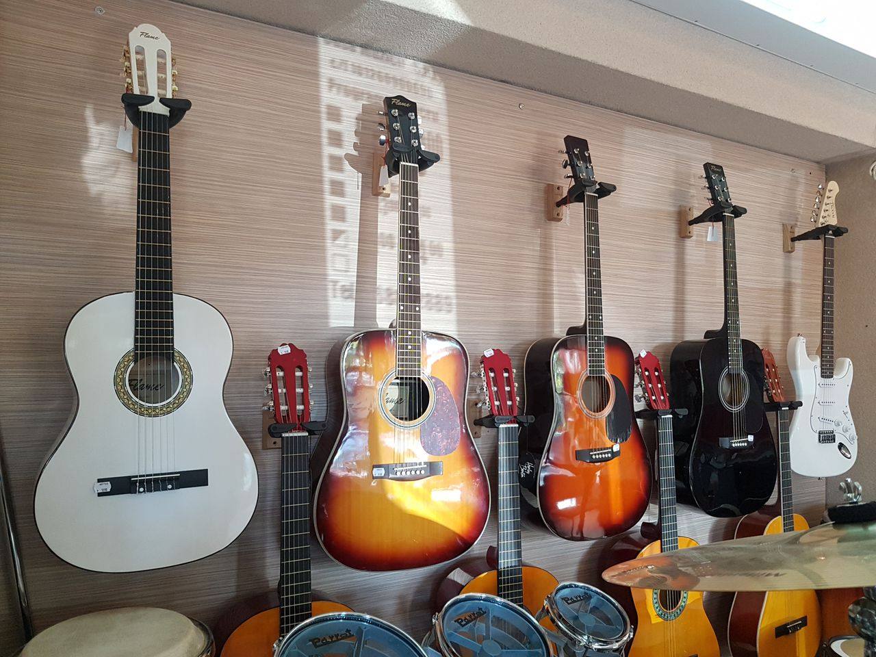 Display wall of acoustic and electric guitars in music shop interior