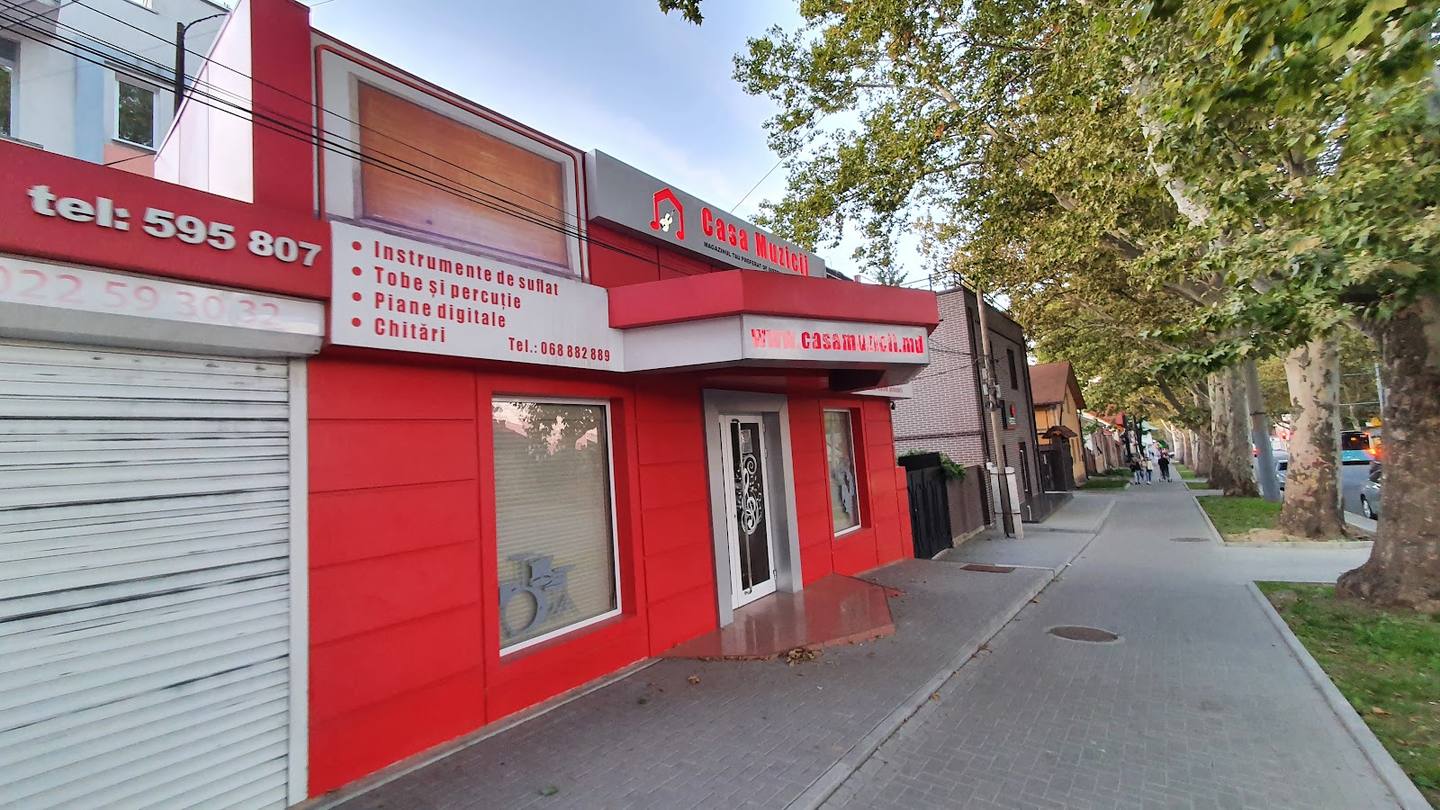 Red storefront facade with street signage and entrance visible from sidewalk