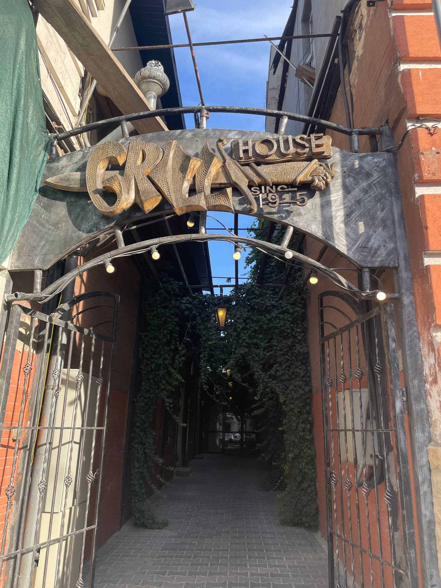 Graft House storefront with brass signage and ivy-covered entrance alley