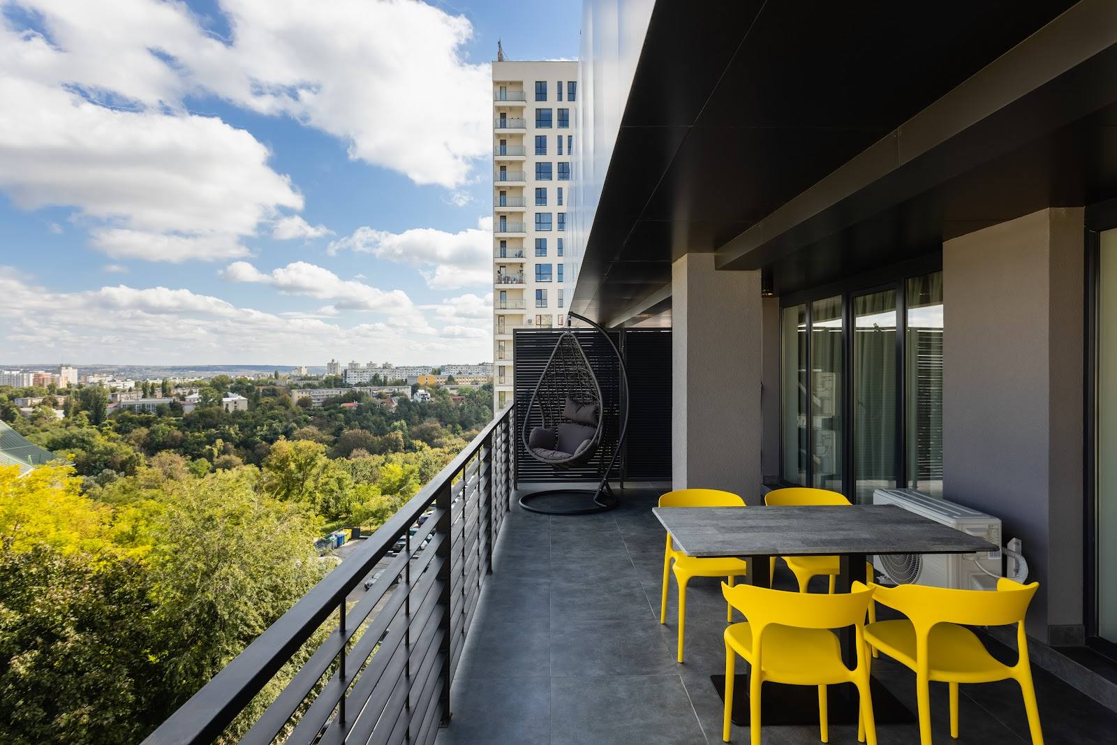 Modern rooftop terrace with yellow seating, city views, and contemporary architecture