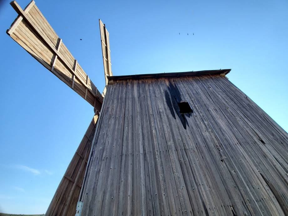 Traditional wooden windmill against clear blue sky