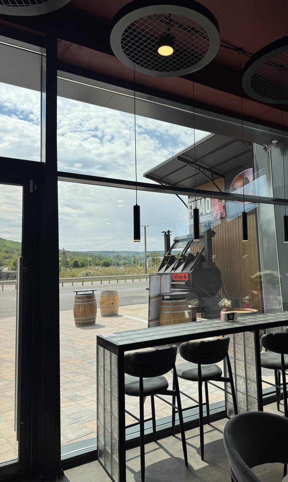 Modern wine bar terrace with panoramic countryside views and barrel seating