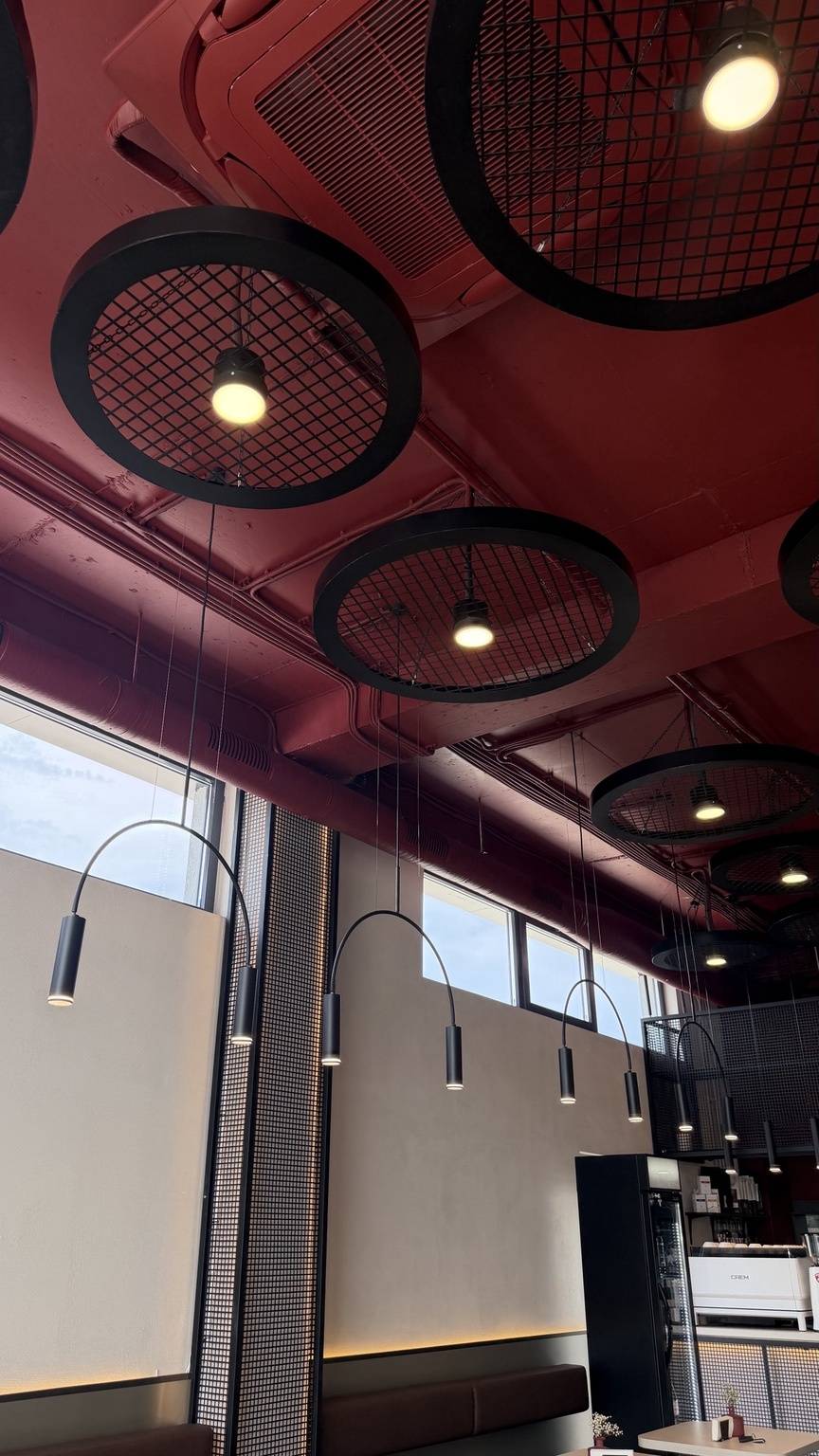 Modern interior with red ceiling, mesh lighting fixtures, and contemporary pendant lights