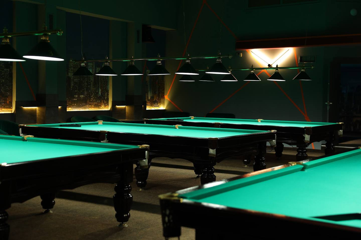 Billiard hall with illuminated pool tables and atmospheric lighting