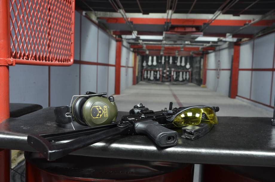 Paintball arena with markers and protective gear on display counter