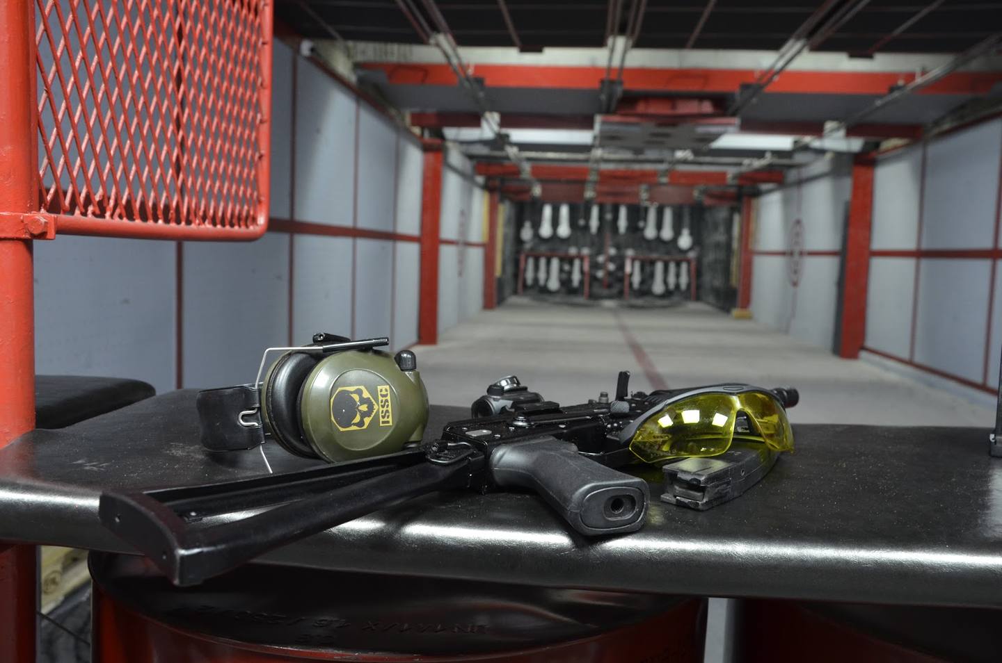 Paintball arena with markers and protective gear on display counter