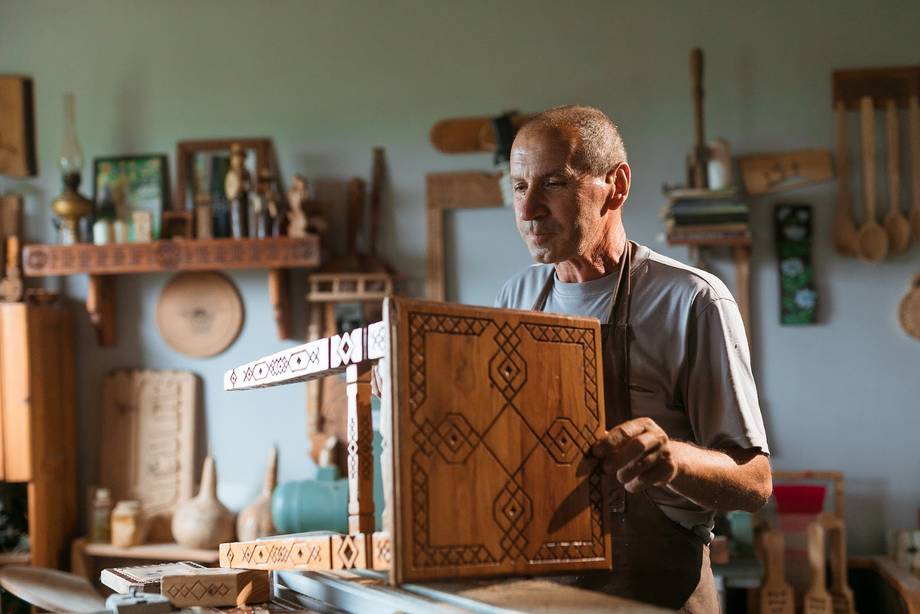 Craftsman demonstrates leather tooling in traditional workshop studio