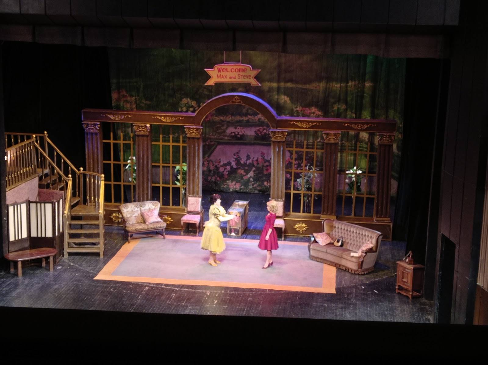 Theater stage set with period architectural backdrop and performers in costume