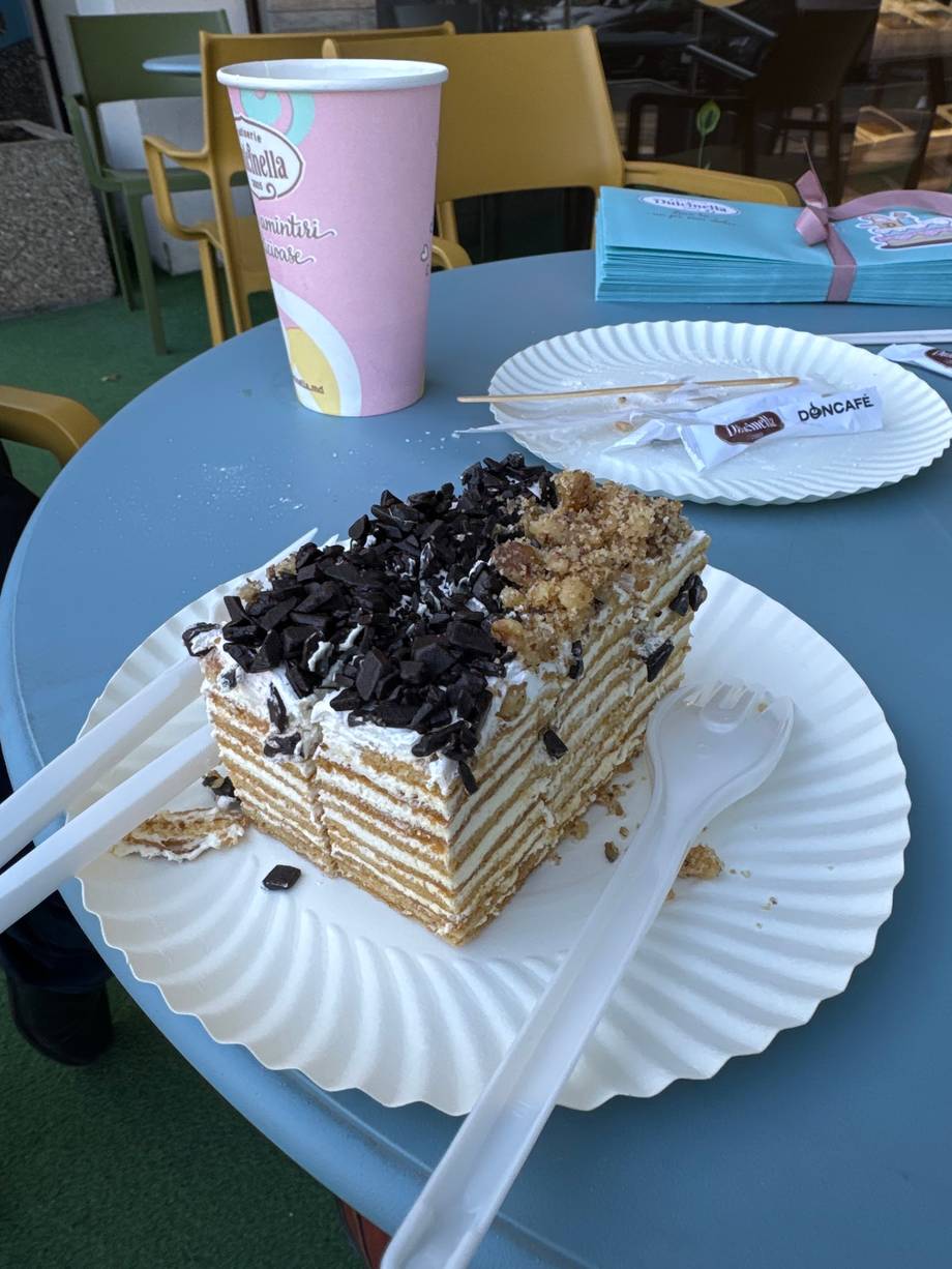 Layered cake with chocolate topping and beverage on blue table