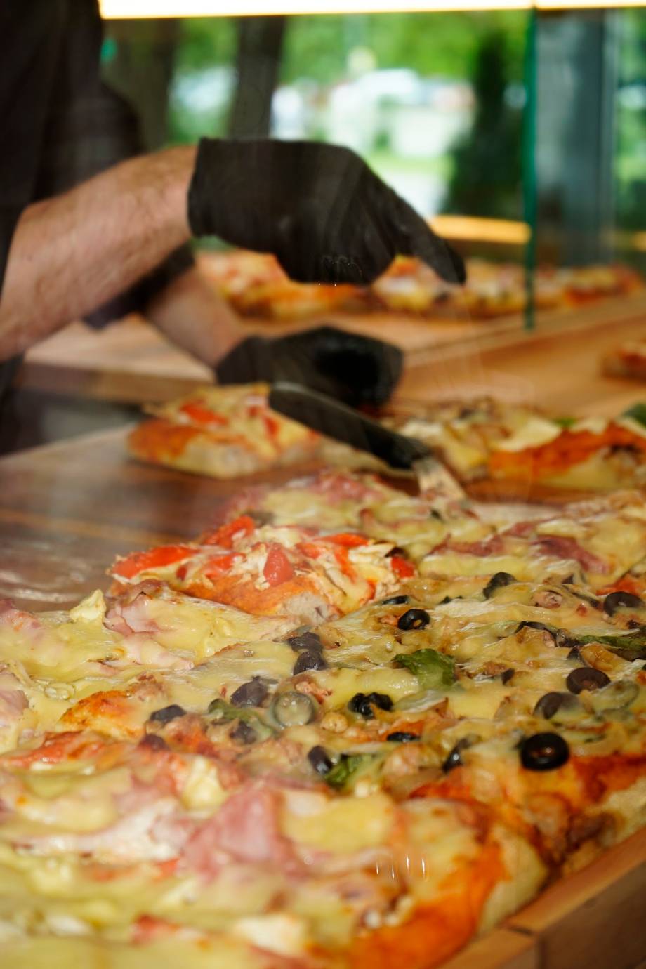 Pizza preparation with fresh toppings on wooden counter