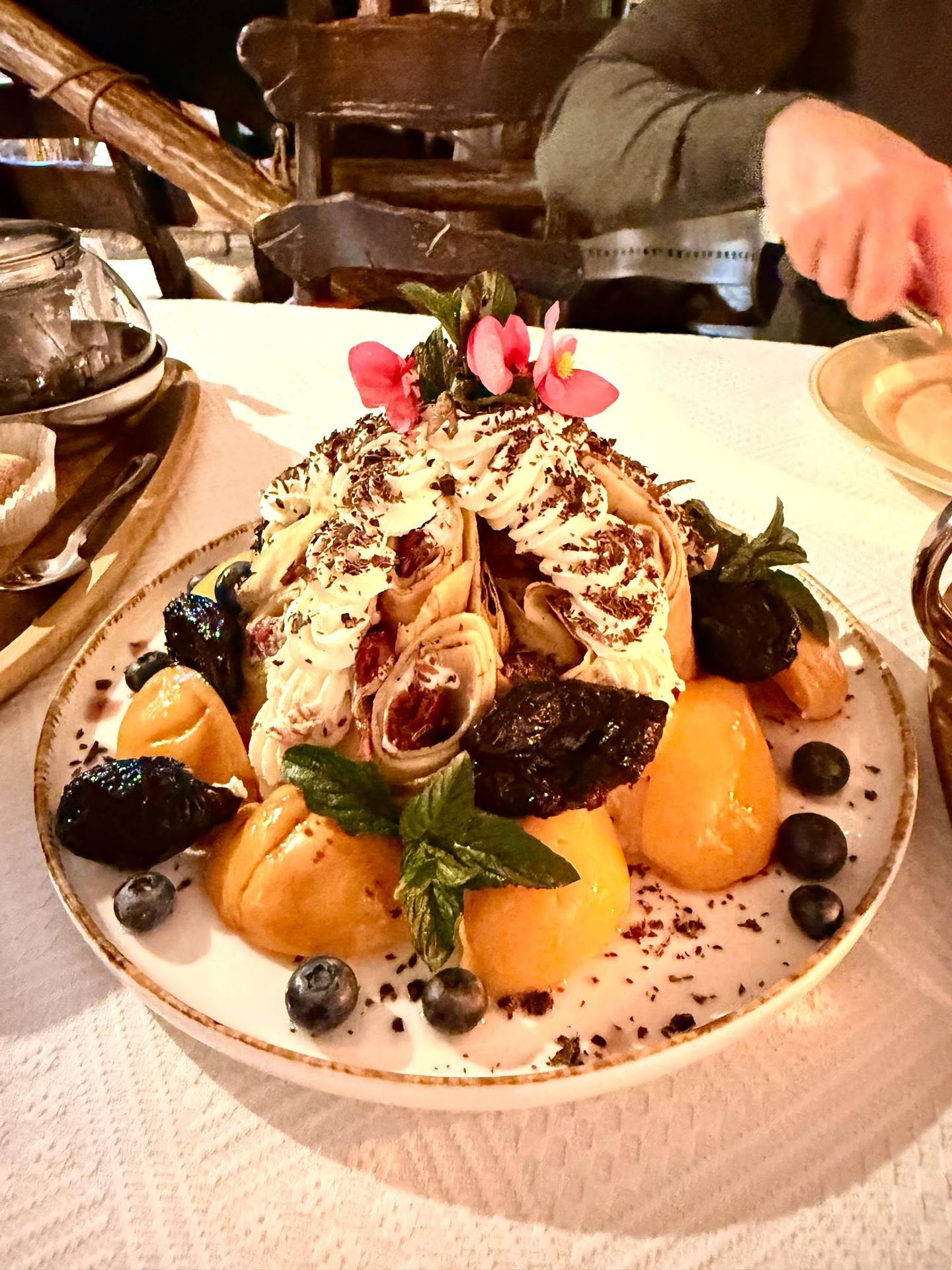 Elegant plated dessert with berries, citrus, and cream garnish