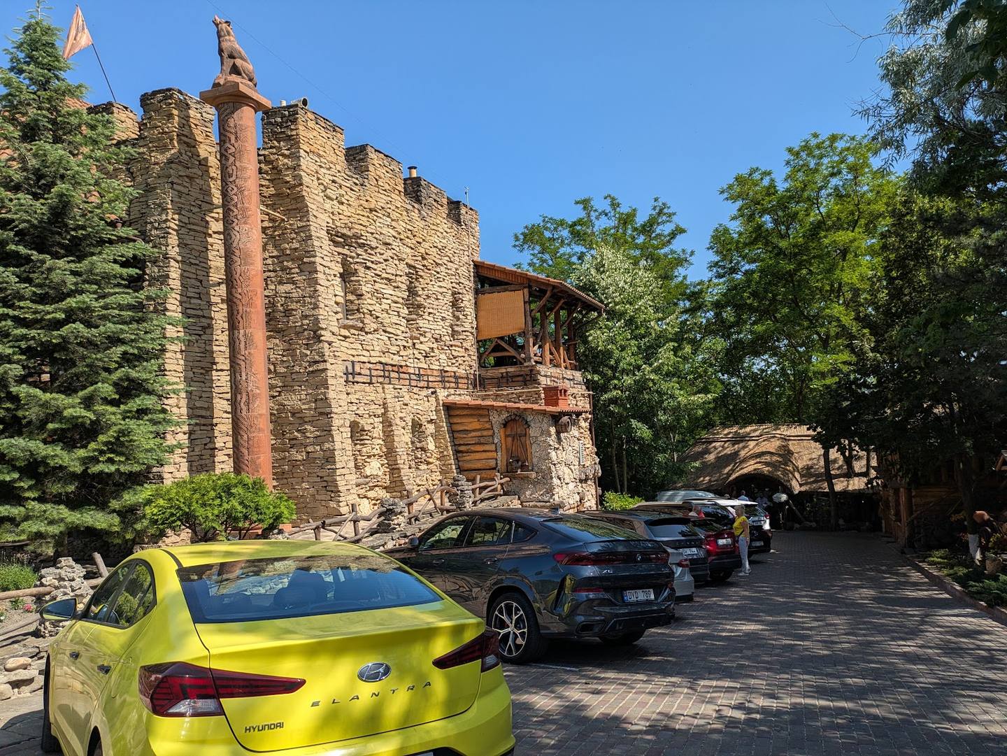 Historic fortress exterior with stone tower and parked vehicles