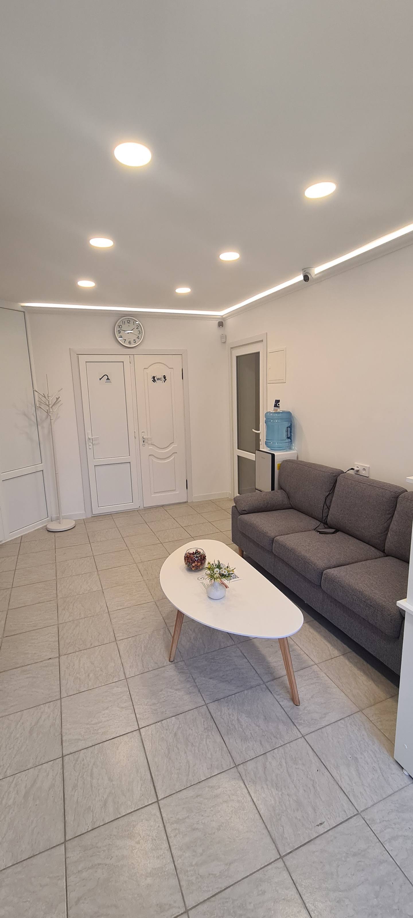 Modern waiting area or reception room with gray sofa and white doors