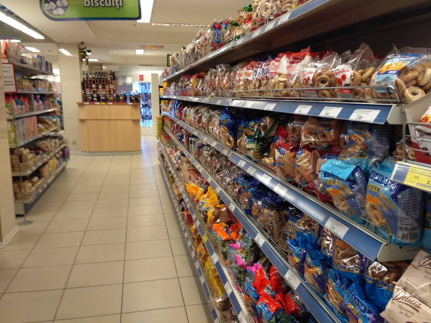 Interior aisle of convenience store with stocked shelves of packaged goods and products