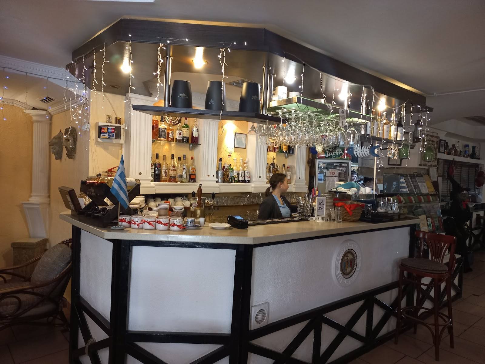Corner bar counter with backlit bottle display and wooden seating in intimate lounge setting