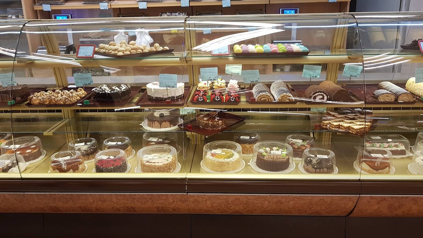 Bakery display case with assorted cakes, pastries and bread products