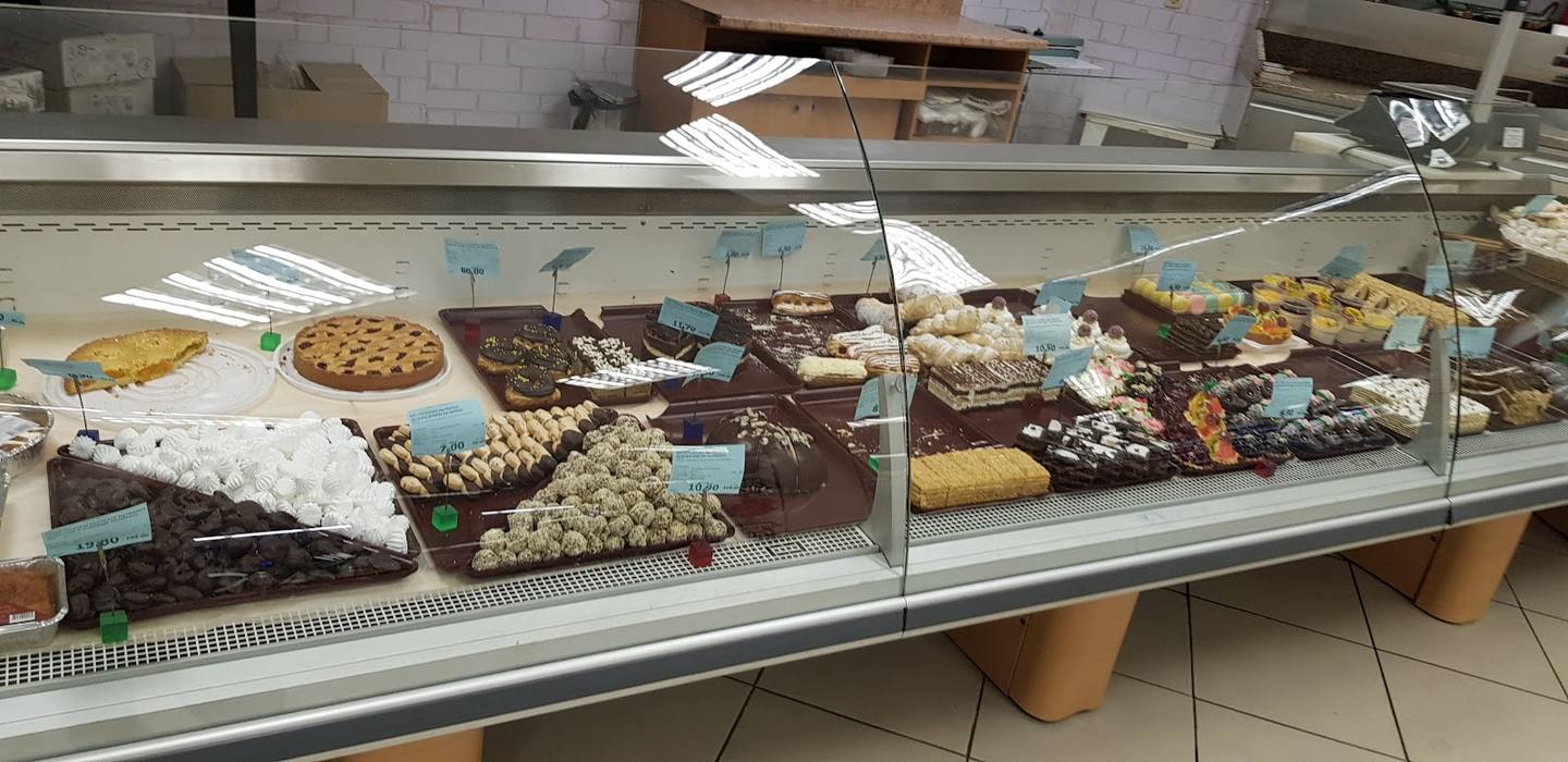 Bakery display counter with pastries and baked goods under glass