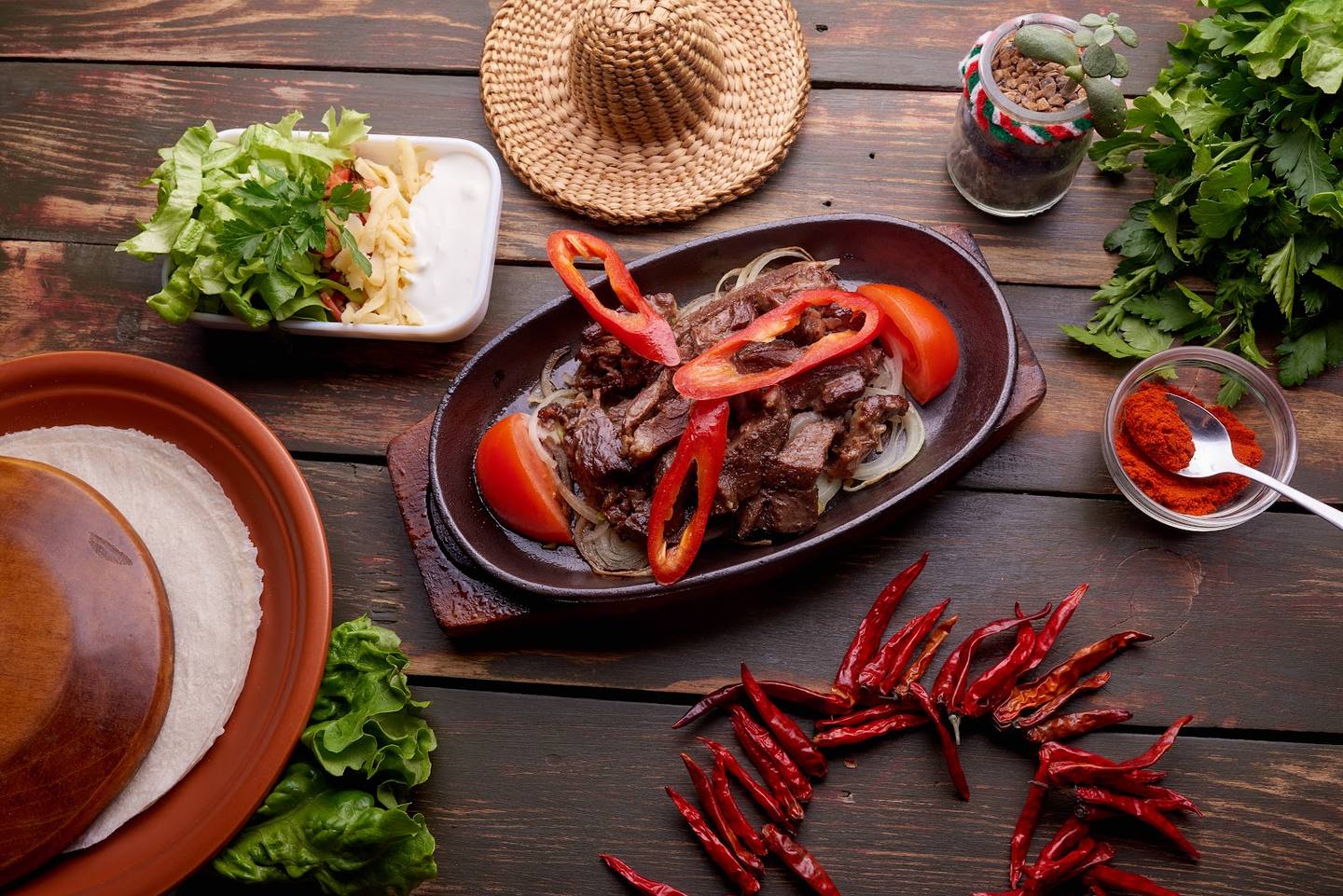 Asian cuisine spread with stir-fried meat and fresh ingredients on wooden table