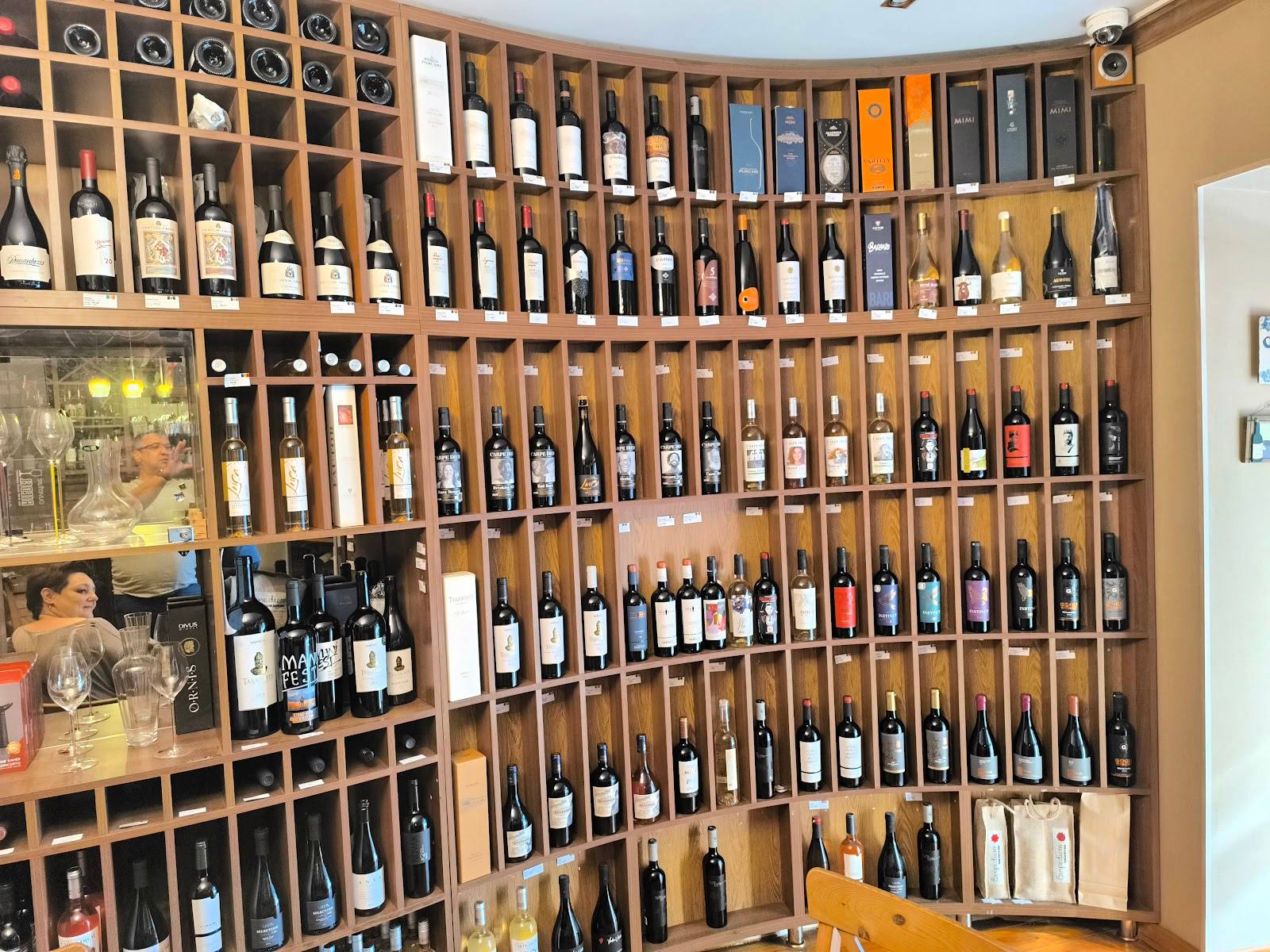 Extensive wine collection displayed in wooden wall shelving with hundreds of bottles