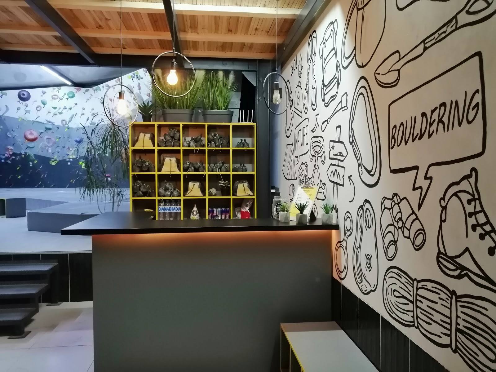 Modern cafe interior with branded wall art, shelving display, and counter seating