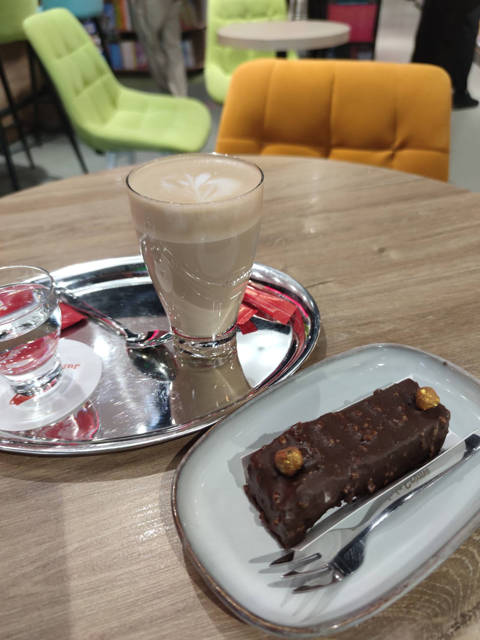 Latte and chocolate dessert at a modern café with colorful seating