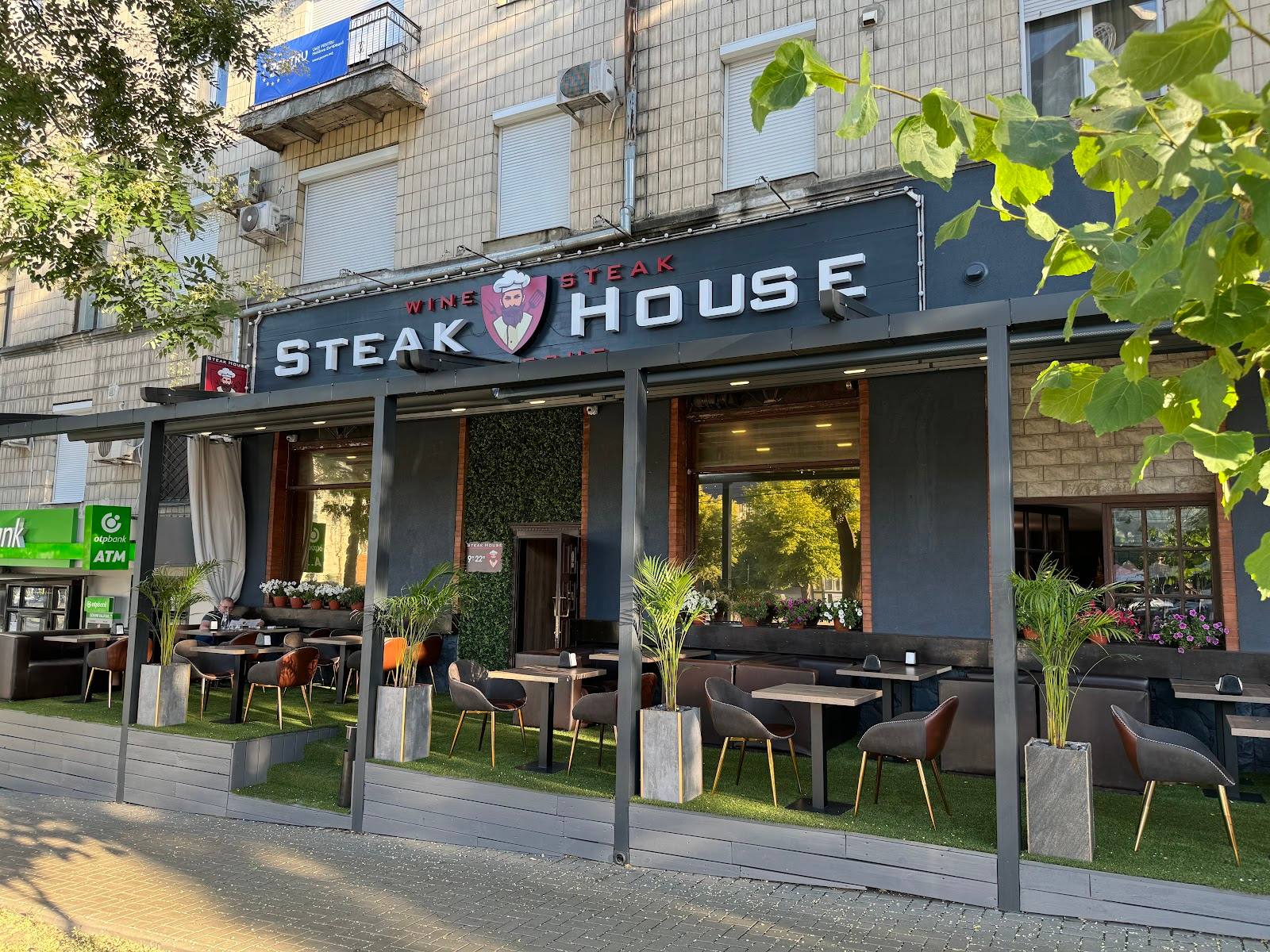 Steak House storefront with modern facade, terrace seating, and green plant accents
