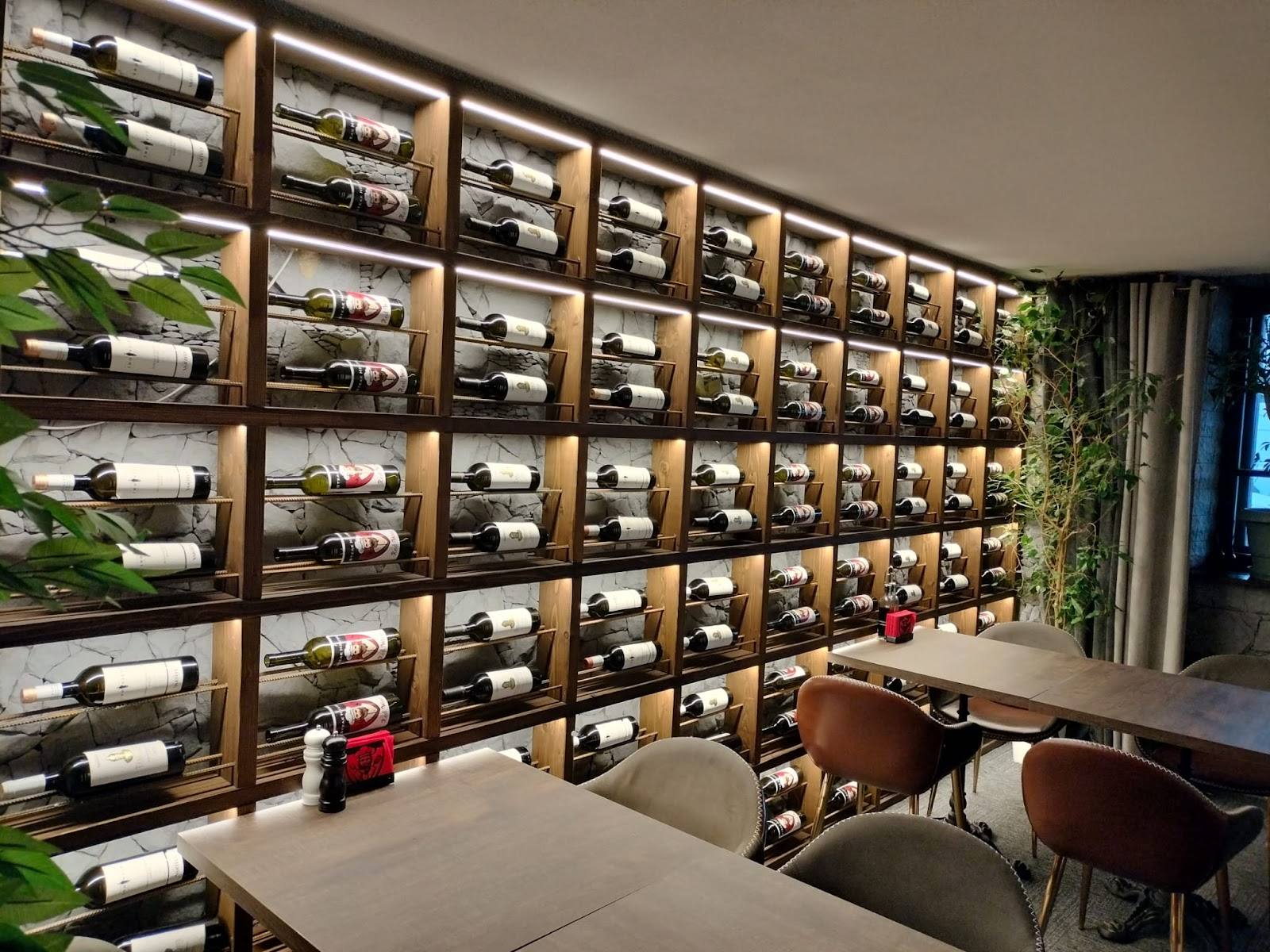 Wall-mounted wine display with wooden box shelving and tasting area below