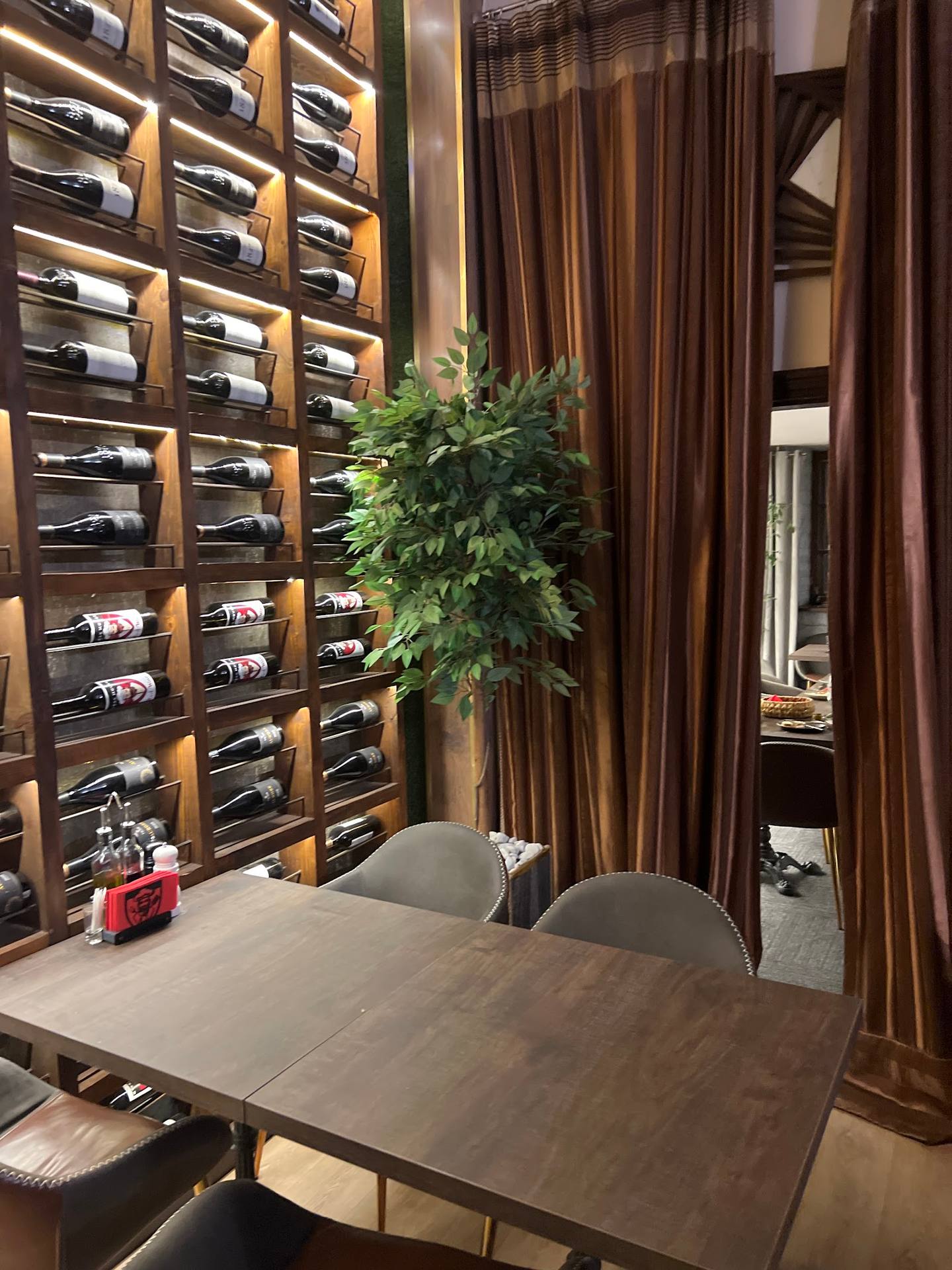 Wine cellar tasting room with temperature-controlled display wall and elegant wood furnishings