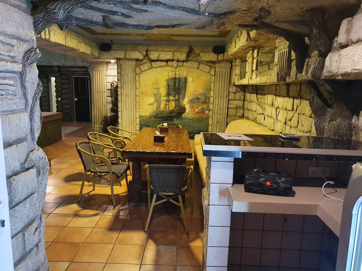 Rustic interior with yellow stone walls, wooden furniture, and warm ambient lighting