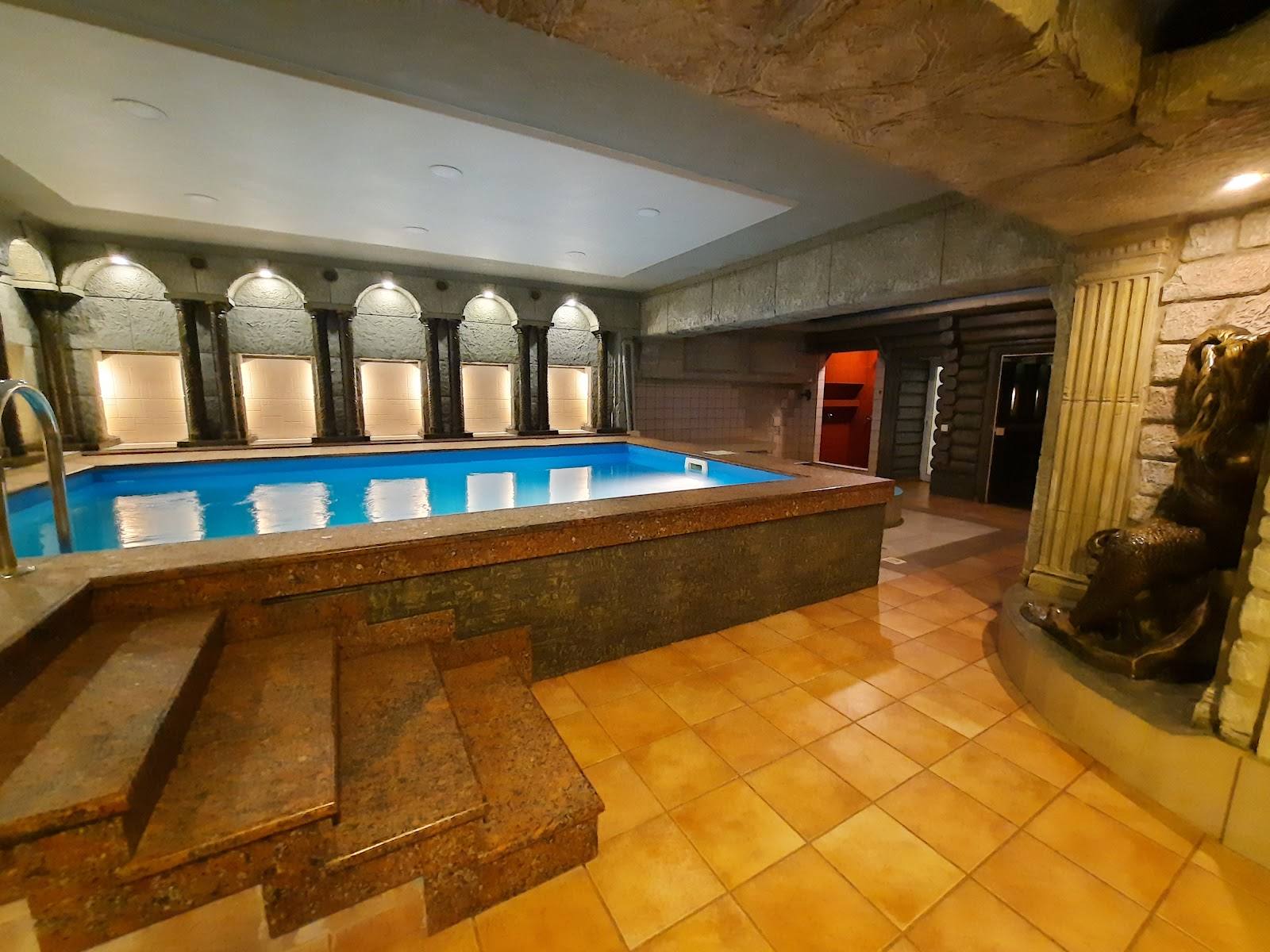 Spa interior with indoor pool, stone steps, and massage treatment areas