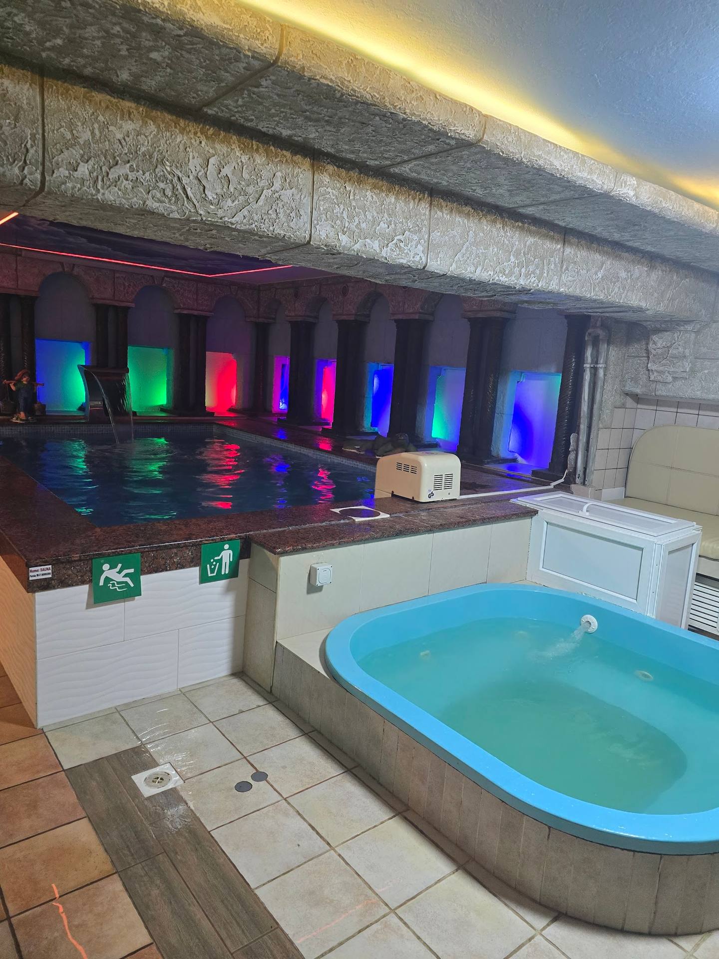 Spa interior with illuminated pool and hot tub in wellness facility