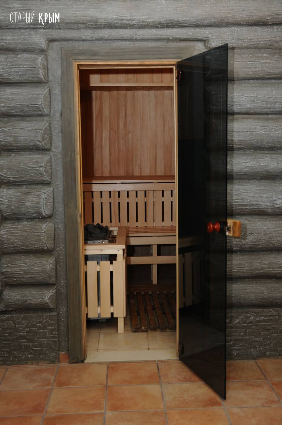 Sauna interior with wooden benches and traditional log cabin facade