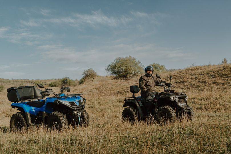 ATV riders on trail through open steppe landscape