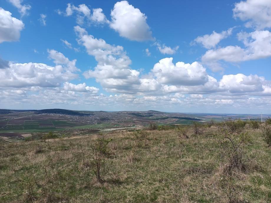Rolling countryside landscape with distant hills and rolling grassland under blue sky